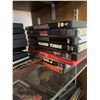 Image 9 : Wood and Glass Shelf Unit With DVDs, Remote Controls, Plush Tiger, and Decor Items
