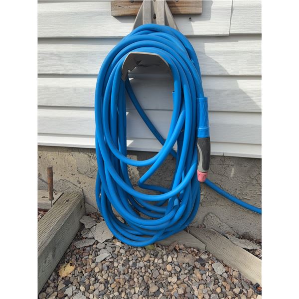 Blue Garden Hose With Spray Nozzle and Outdoor Wall Mount
