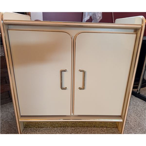 Metal Cabinet With Shelf and Dual Doors, Cream Finish With Gold Accent Trim