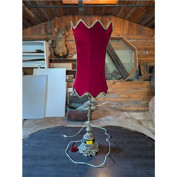 Vintage Hollywood Regency style table lamp. Ornate metal base with red velvet shade.