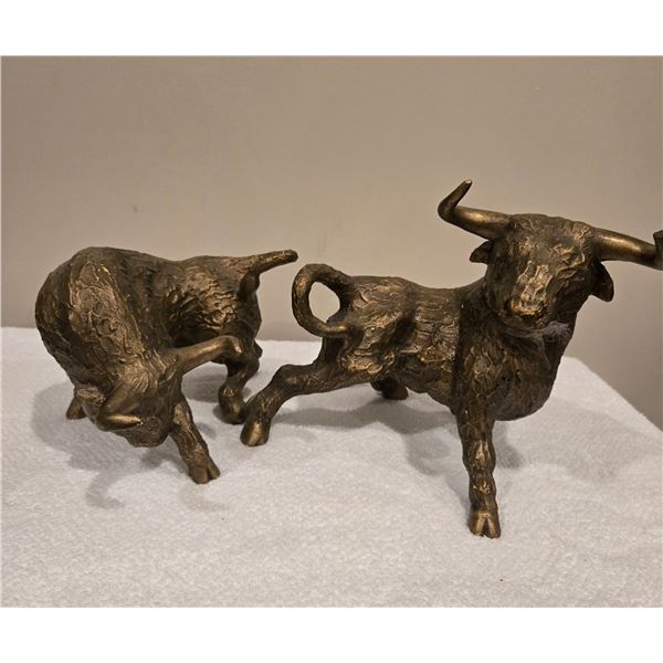 Pair of ceramic brass-toned bull figurines.  Approx 10" long, 8" tall
