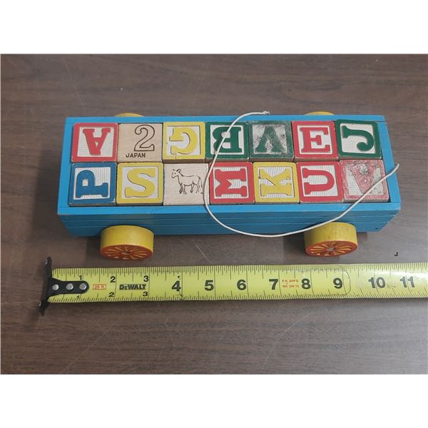 Vintage wooden pull-along toy wagon filled with alphabet and picture blocks.