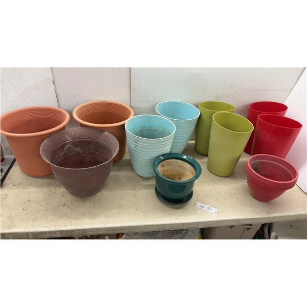Assorted Plastic Planter Pots in Various Colors and Sizes with Green Ceramic Pot