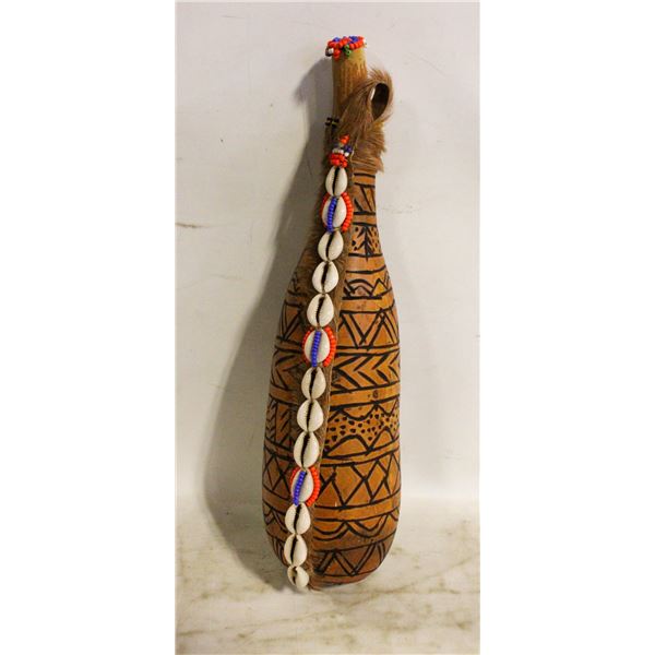 GOURD VESSEL DECORATED WITH FUR AND SHELLS.