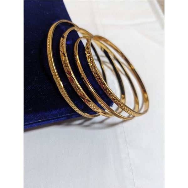 4 18K GOLD PLATED BANGLES, ALL DIFFERENT RAISED ENGRAVED DESIGNS