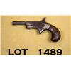 Image 2 : Small unmarked single shot derringer, .22 cal.,  2-1/2” barrel, nickel finish, wood grips, #NVSN.  T