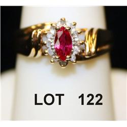 Marquis cut ruby ring surrounded by diamonds,  mounted in diminutive 10kt gold setting. A  beautiful