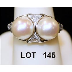 Two large pearls, beautifully  mounted in  platinum with fancy triangle and oval  accents. An outsta