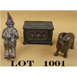 Lot of three old metal banks including a  clown approx. 6” tall, a lion approx. 4” x  5”, and a safe
