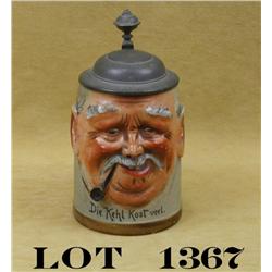 Older German-style stoneware stein approx. 6”  tall and with a pot metal lid with raised  face of an