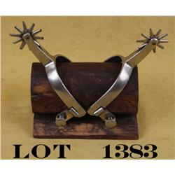Northern Judd Spurs with nickel finish.  Clearly marked with anchor, on a wood stand.  Est.: $60-$12