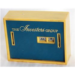 THE INVESTORS GROUP. A rectangular Coin Calendar bank. Two coin slots on front. Currency slot on bac