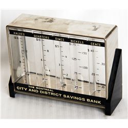 THE MONTREAL CITY AND DISTRICT SAVINGS BANK. A rectangular clear plastic bank with black highlights.