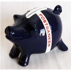 POSTIPAUKKI. Piggy Bank shaped. Black plastic with a white band. Coin slot on top. 6cm x 7cm x 10cm.