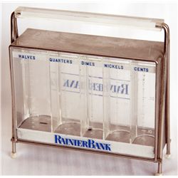 RAINIER BANK. Rectangular clear plastic bank with blue highlights. No key. Five coins slots along fr