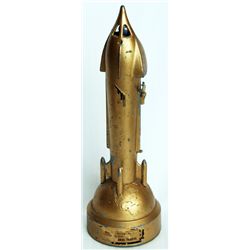 GEN…ERAL TRUSTS. A Rocket shaped ‘Mechanical’ bank. 8 1/2cm base. 26cm in height. Steel, with a gold