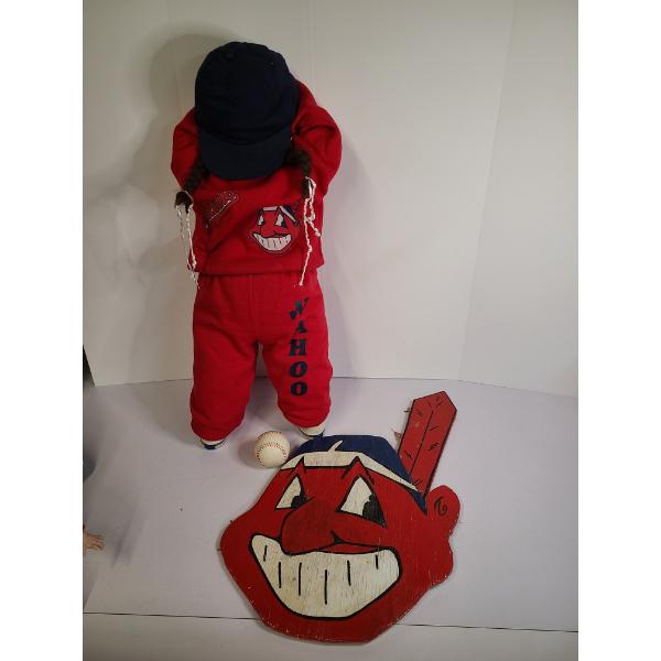 A doll dressed in a red outfit featuring the historic "Chief Wahoo" logo and text markings