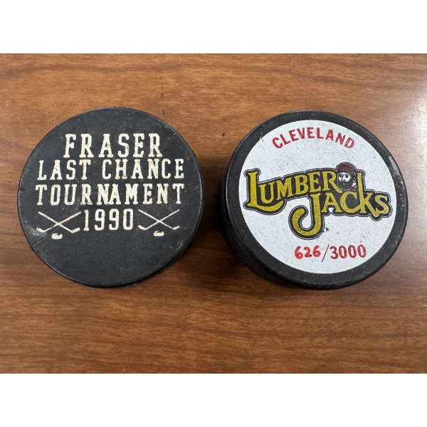 2 - Real Hockey Pucks Inc;uding A Numbered Cleveland Lumber Jacks Puck
