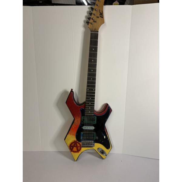 Modified B.C. Rich Warlock electric guitar with a custom painted red, yellow, and black finish 