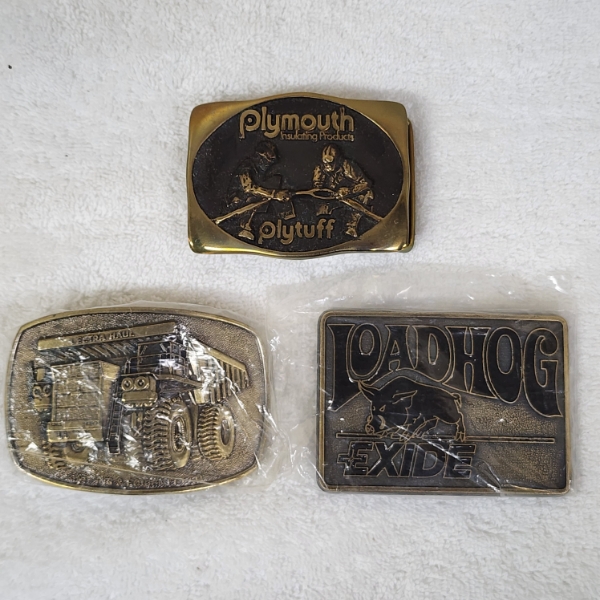 Three Assorted Vintage Collectible Belt Buckles Ft. Lectra Haul, Loadhog Exide & Plymouth Insulating