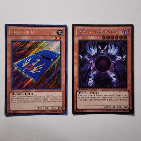Two Holo Yu-Gi-Oh Trading Cards Including 1st Edition Caius The Shadow Monarch PGLD-EN066