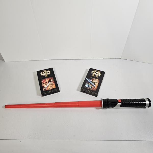 Two Star Wars VHS Tapes And Red Lightsaber Toy