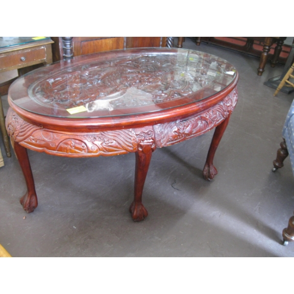 HEAVILY CARVED ASIAN LOOK GLASS TOP COFFEE TABLE