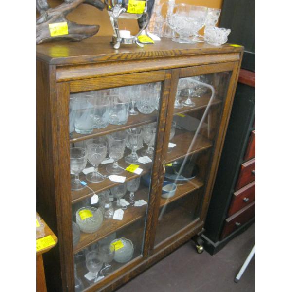 GLASS DOOR OAK DISPLAY CABINET ON CASTORS