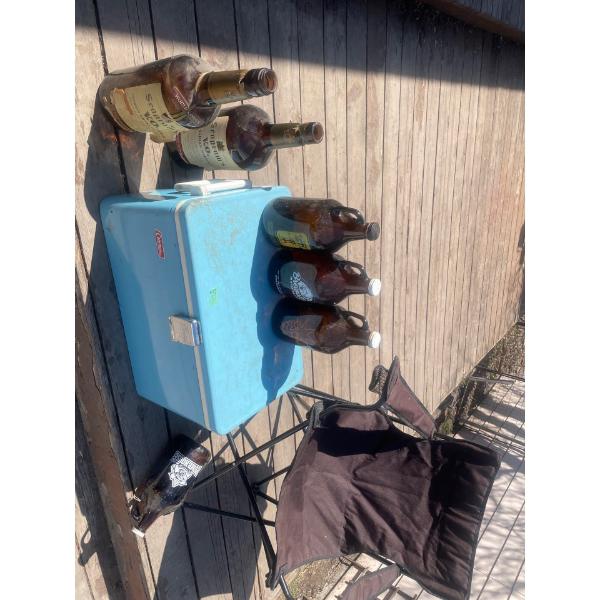 Foldable Lawn Chair, Vintage Cooler, 2 Empty Texas Mickeys, 4 Empty Beer Jugs.