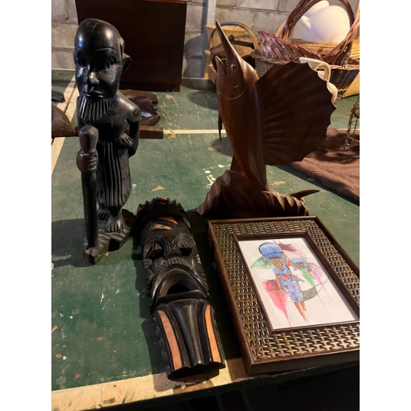 collection of African art, two statues, one solid, handmade, wooden sailfish, and a small African pa