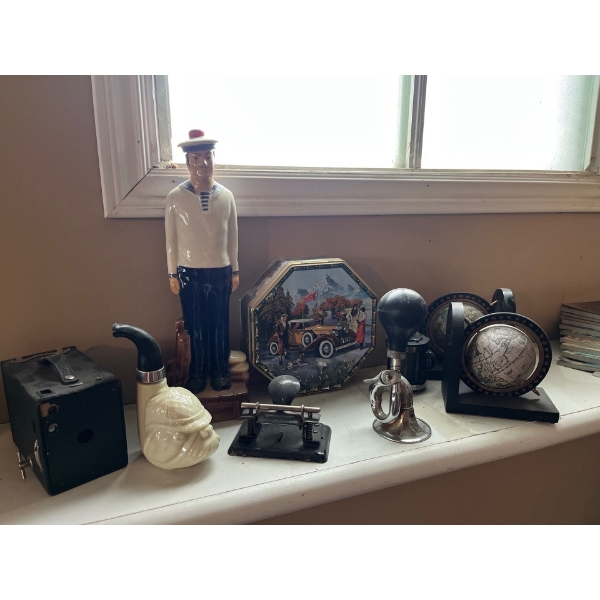 Antique sailor sculpture, pinhole, camera, collector tins, globe bookends, vintage bike-horn and an 