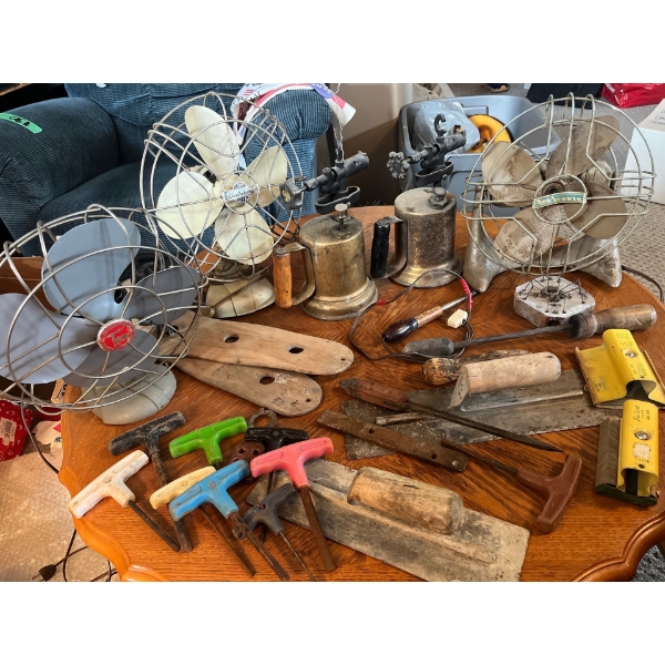 Collection of vintage tools, fans, and kerosine blow torches