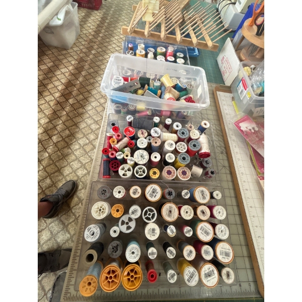 several new and slightly used bobbins of thread, including thread holders sold altogether