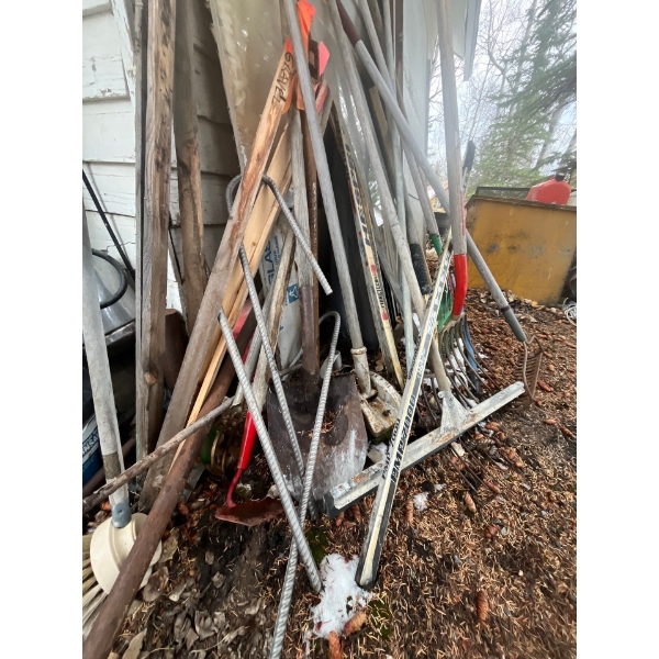 collection of pick shovels, hockey sticks, Brodie 15 pound packer.