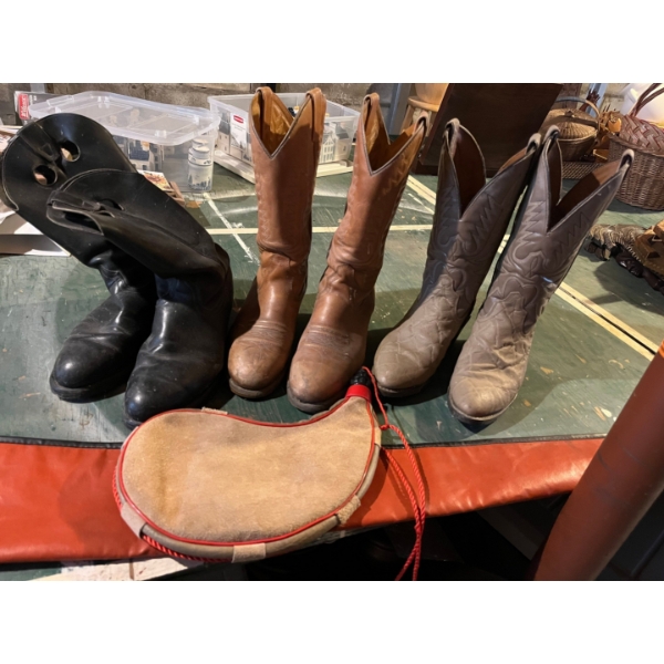three pairs of leather vintage cowboy boots with a vintage gun case and leather flask
