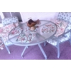 Image 1 : Glass Patio Table with Metal Frame, Two Chairs, Cushions, and Decorative Accents