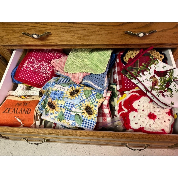 Drawer full of placemats hot pads, tea towels and table cloths 