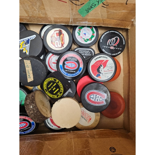 Various Hockey Pucks with Logos and Designs