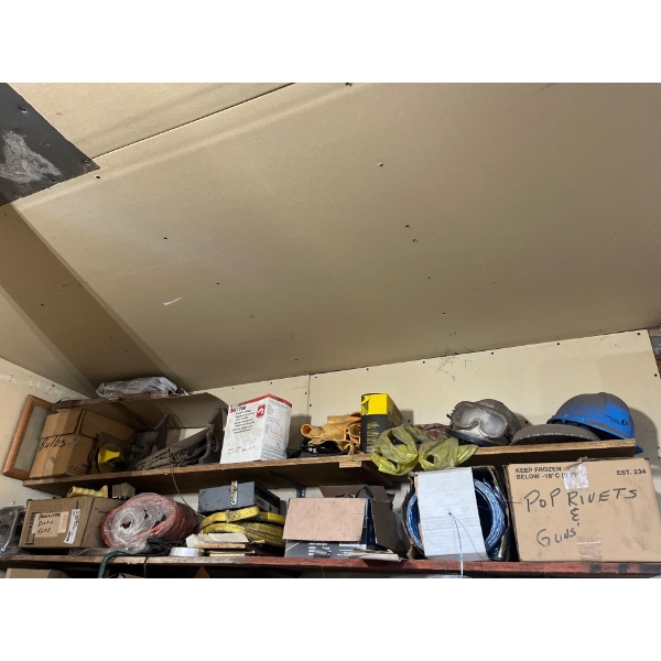 Top two shelves with several miscellaneous items, tools, hardhats boxes of rivets boxes of rope, air