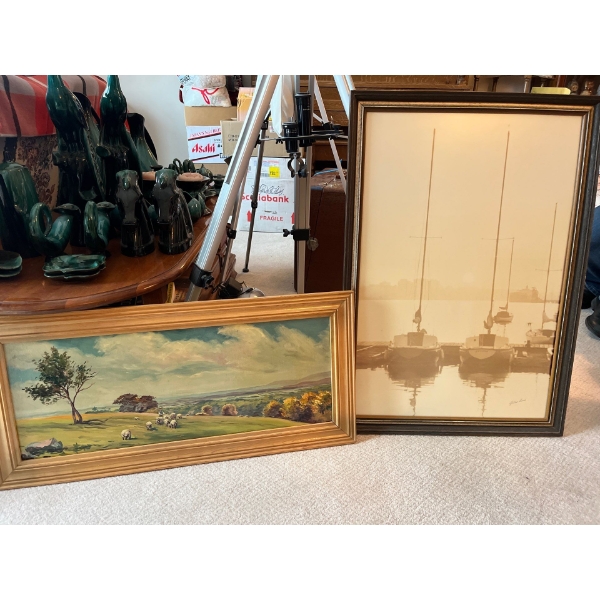 two framed prints, one of two sailboats, and the other is a painting of sheep on a hillside