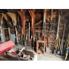 Image 1 : All Yard items on the wall, including pitchforks shovels brooms all sorts of shovels chains 
