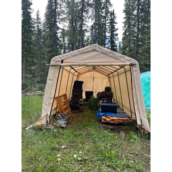 Carport with contents made by shelter logic in good condition also a pile of tongue and groove board