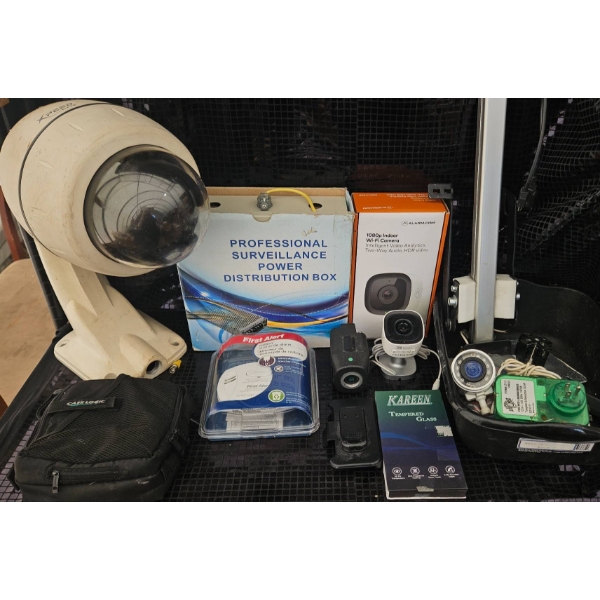 Surveillance Equipment Lot Featuring Cameras, Power Distribution Box, and Accessories