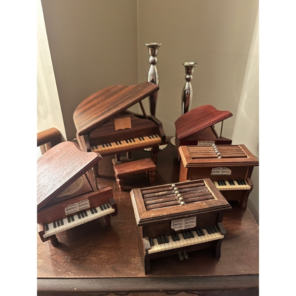 Collection of piano, music boxes, and vintage coaster sets with silver candleholders