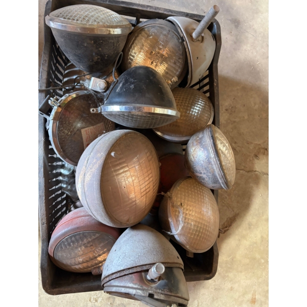 box full of vintage antique tractor lights all various sizes and manufactures

