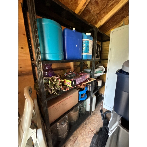 Two metal storage shelves with contents, 320 L water jugs, hammocks lights, tarps, glass carboys, an