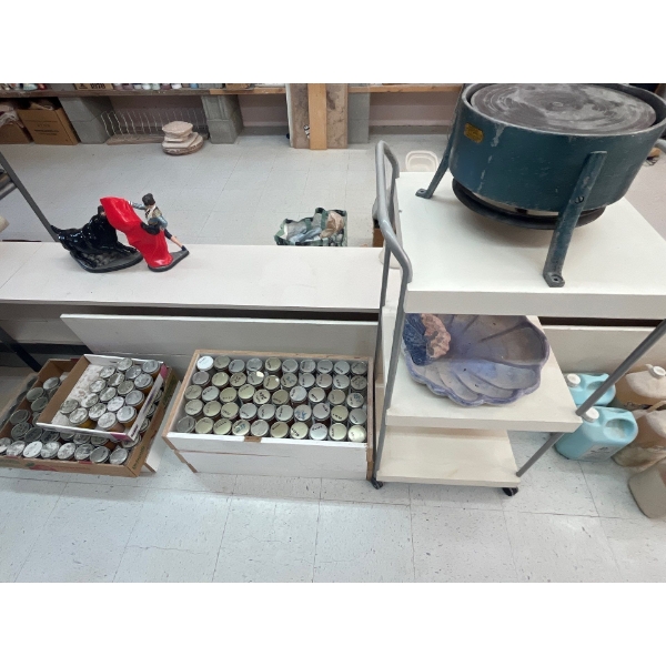  rolling shelf with seashell and Canadian lapidary supply Co. pottery, spinner, and two trays and a 