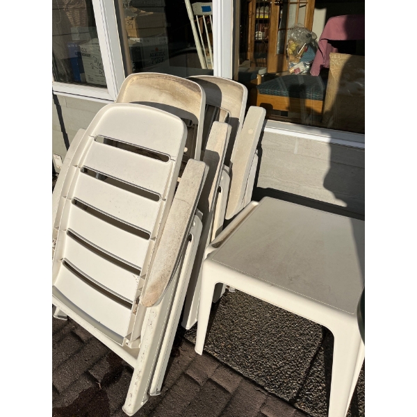Three plastic, folding chairs and white plastic side table