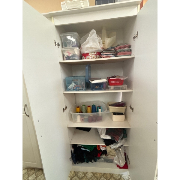  cabinet full of quilting, supplies, a number of large rolls of thread, several zippers, and a numbe