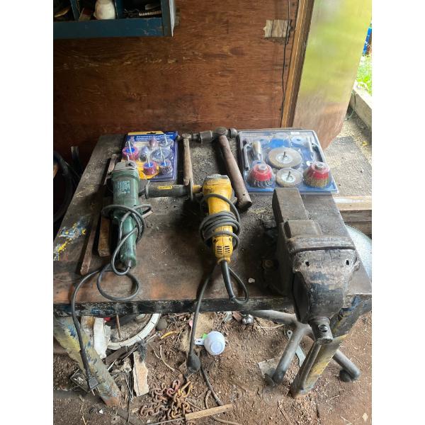 welding table with two grinders and grinding tools and two hammers